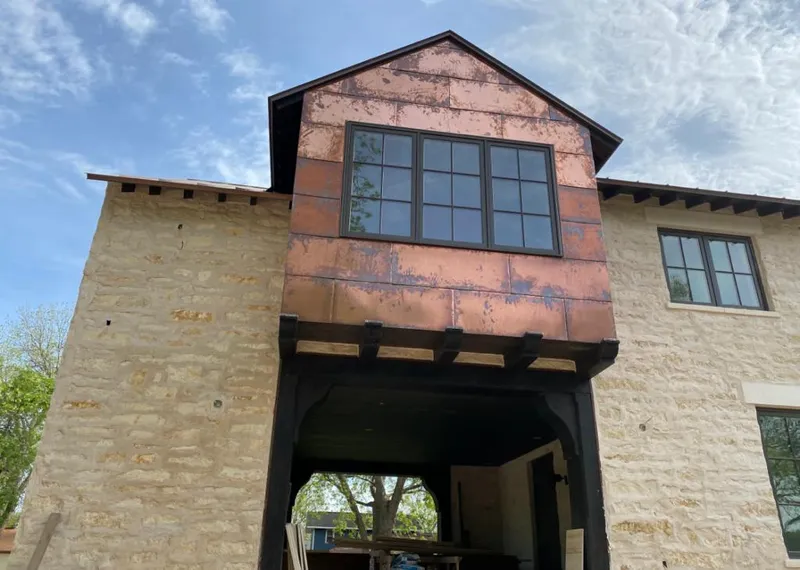 Copper metal panel facade on a stone building for Metal Roof Coating in North Liberty