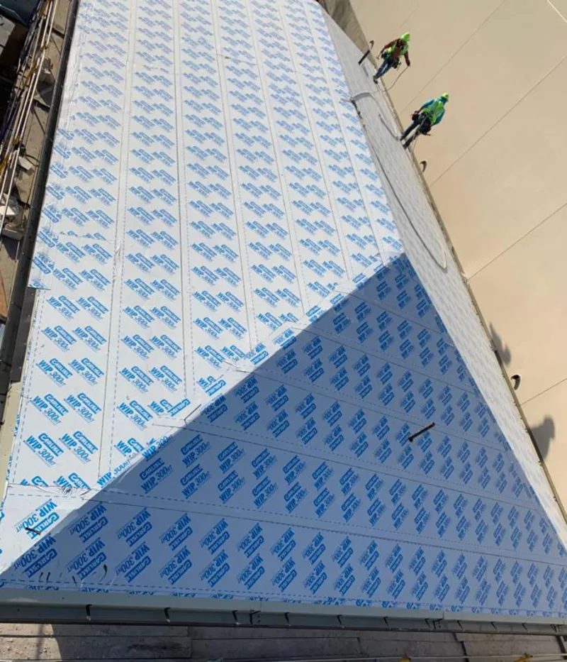 Professional roofers installing underlayment on a metal roof in North Liberty